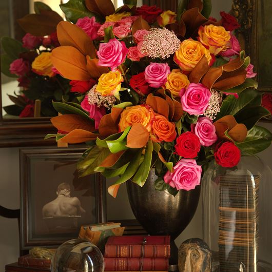 Assorted rose arrangement featuring rice flower and ornamental foliage.