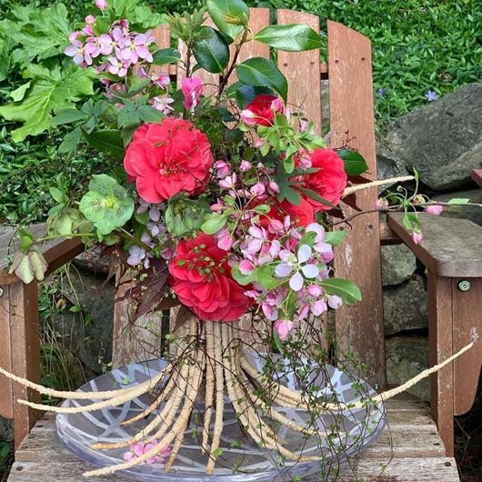 Nature-inspired standing root structure featuring assorted garden botanicals.