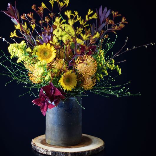 Assorted sunflowers, Leucadendron, Protea and kangaroo paw flowers decorate this fall inspired display.
