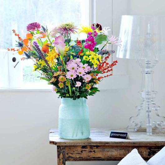 Chrysanthemums and other bright blooms set the scene in this tableside arrangement.