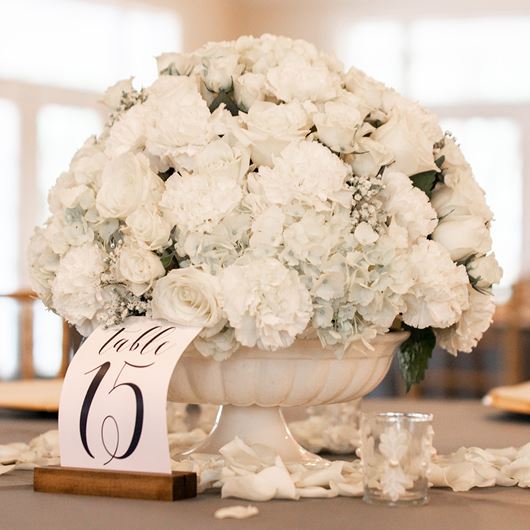 Wedding centerpiece featuring white carnations, roses, Gypsophila and Hydrangea.
