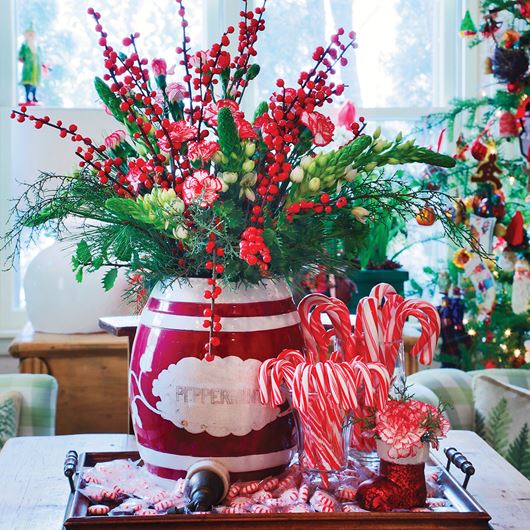An antique peppermint jar serves as the perfect vessel for a mix of winterberries, stars of Bethlehem and mini peppermint carnations.