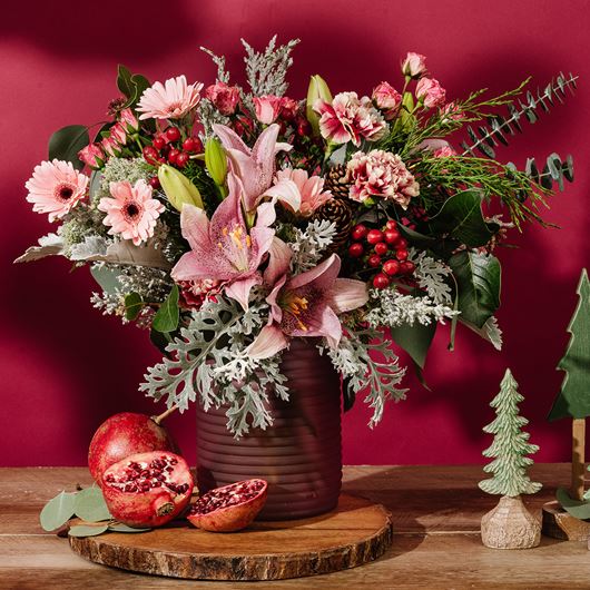 Holiday arrangement featuring clear pinks, Christmas reds and neutral greens.