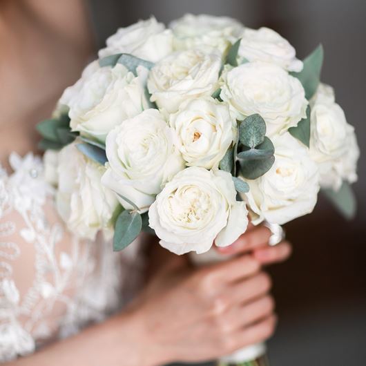 Bridal bouquet featuring white hybrid tea and garden roses.
