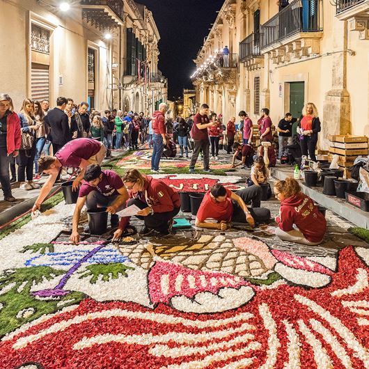 Artists completing a flower carpet at the Infiorata Festival in Noto, Sicily.