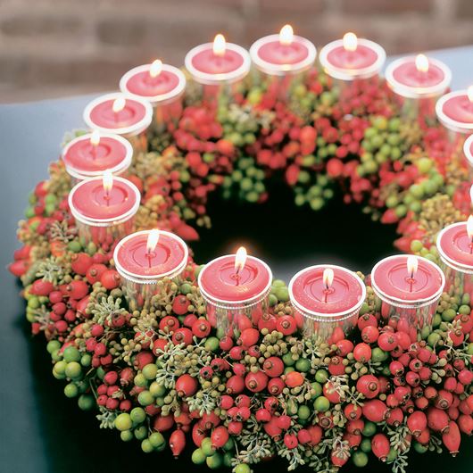 Candlelit wreath centerpiece featuring Chinaberries, Eucalyptus, Skimmia and rosehips.