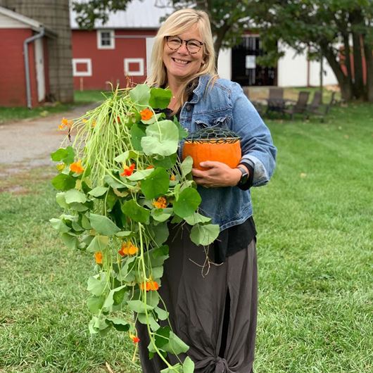 Holly Heider Chapple with home-grown nasturtiums and her Holly Pillow, created in partnership with Syndicate Sales.