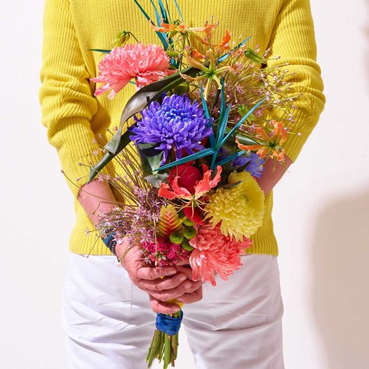 A festive, hand-tied bouquet showcasing brightly-colored Chrysanthemums.