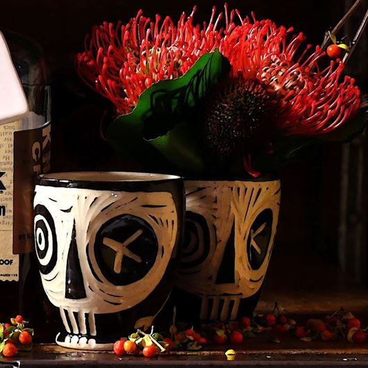 Textured Protea makes a spooktacular accompaniment to whimsical skull containers.